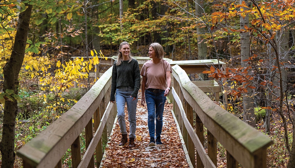 Two women enjoying a walk on a boardwalk.