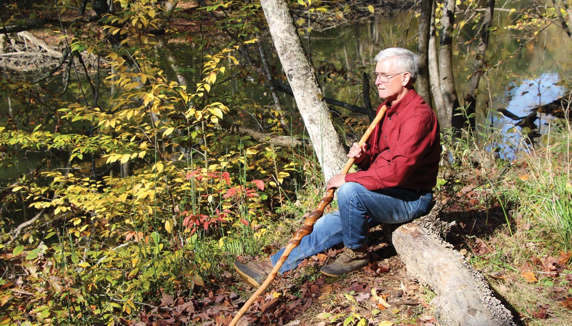 Chip Gross pictured in the woods with his prized walking stick.