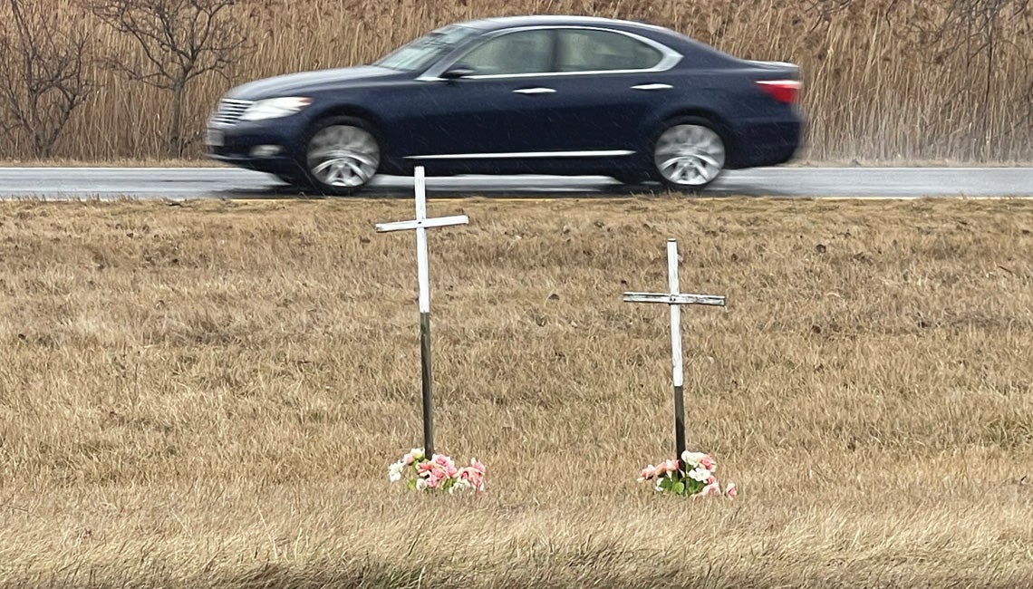 A car driving past a roadside memorial