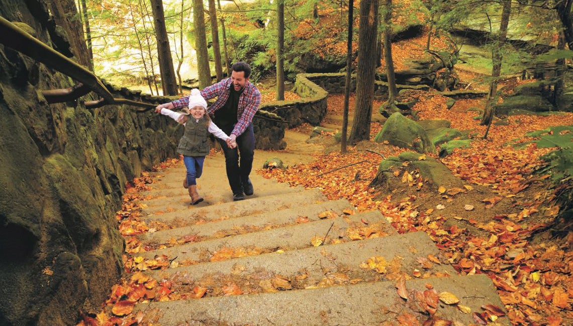 A father and daughter playing in the woods