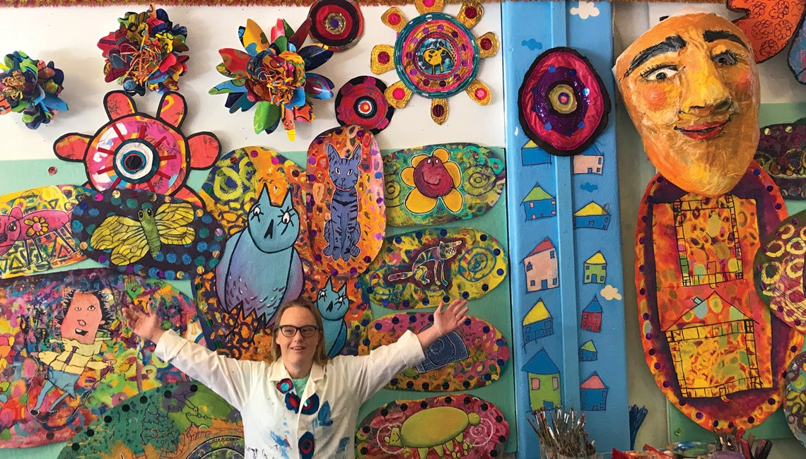 A girl posing with her artwork