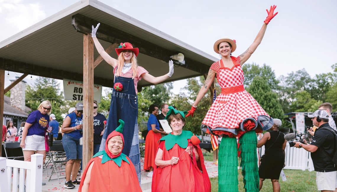 People posing in costumes at a tomato festival