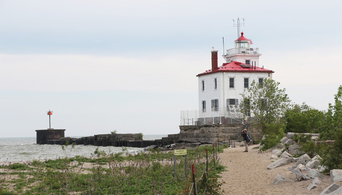 A man standing in front of a lighthouse