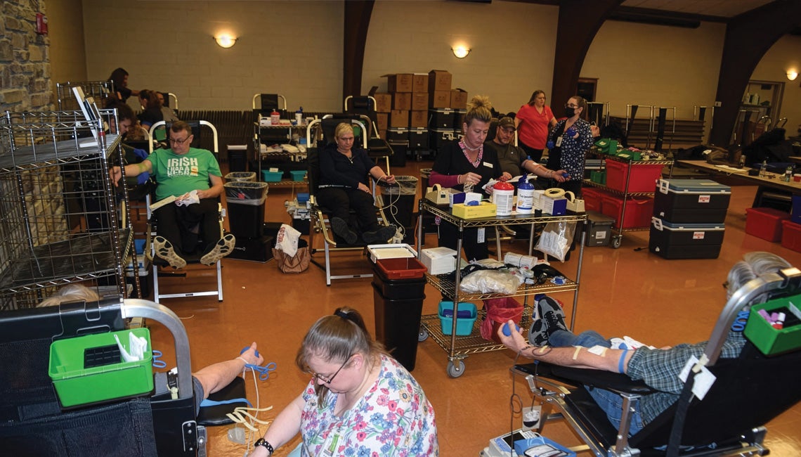 A group of people donating blood during a blood drive