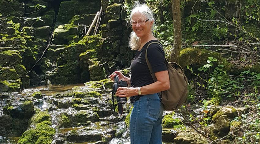 Nancy Stranahan, co-founder and director of Arc of Appalachia smiles for a photo in a forest