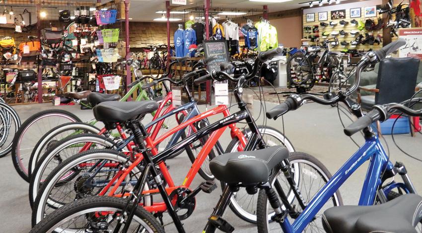 The inside of Bishop's Bicycles, containing multiple bikes, bags, and shirts.