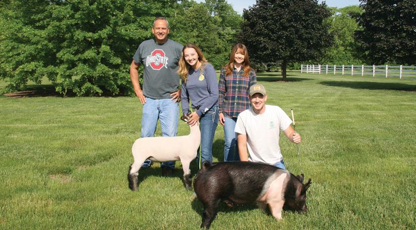The Butterfield Family poses for a picture with their goat and pig.