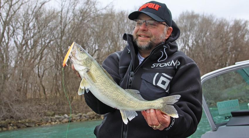 Mark Martin smiles and examines a huge walleye he caught.