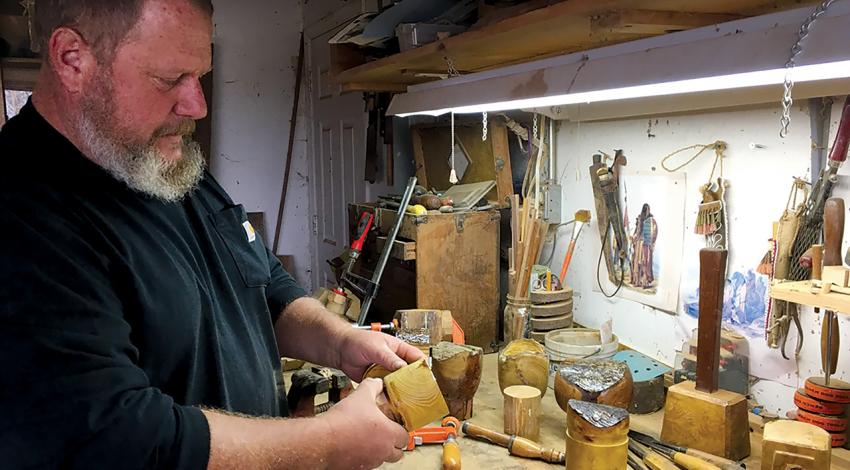 Ken Duerksen puts the finishing touches on a lidded box at his garage worktable. (Photo by Karen Holcomb)