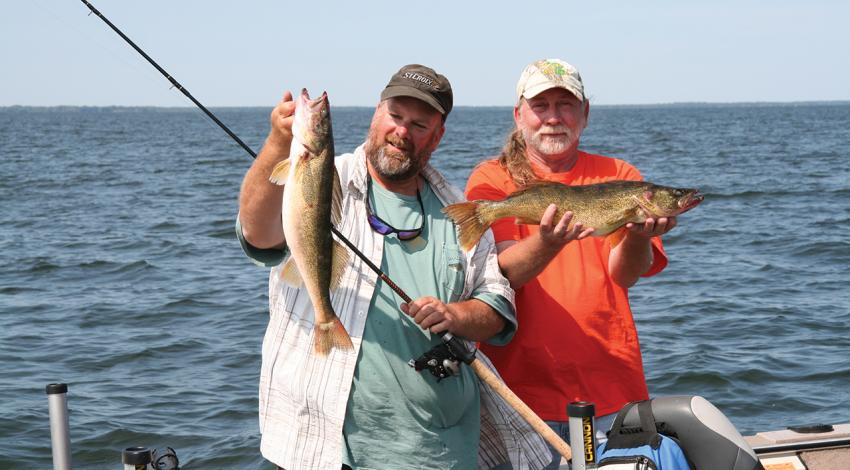 Fishing guide Dave Rose (left) and a client show off part of their catch of Green Bay walleyes during a day on the lake.