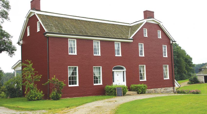 A picture of the outside of the Old Johnston Farm, a large red building.
