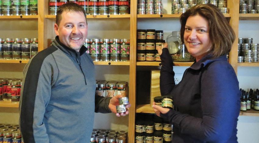 Dawn and Carson Combs pose for a figure alongside jars of products.