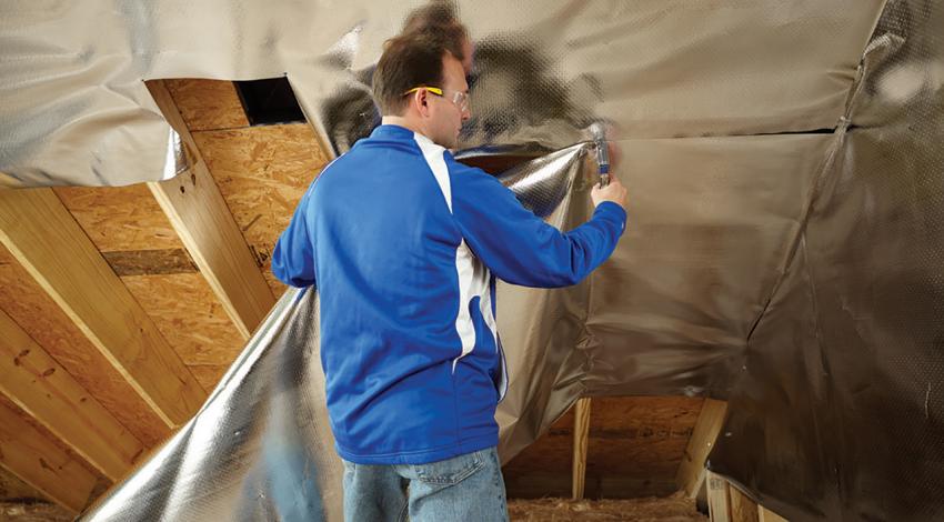 A man attaching a radiant barrier.
