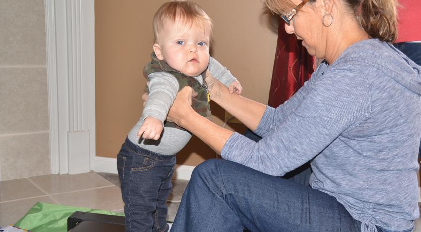 Kathy Fleenor, a pediatric physical therapist from the early-intervention division of Butler County Board of Developmental Disabilities, helps Lucas walk on the infant treadmill for the first time.