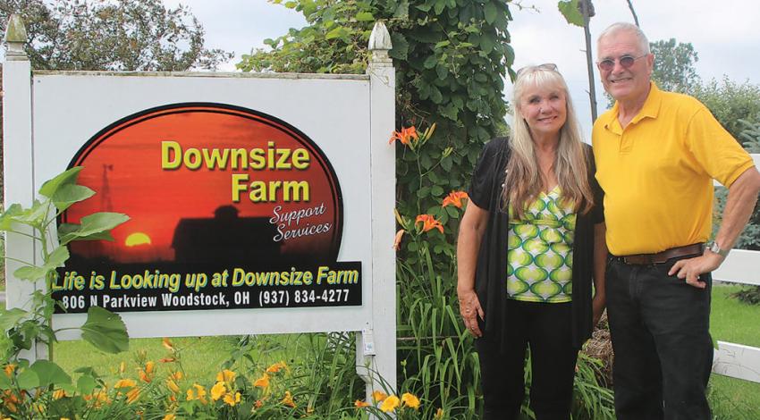 Midge and Bob Custer, of Woodstock, Ohio, pose next to the sign for their farm.