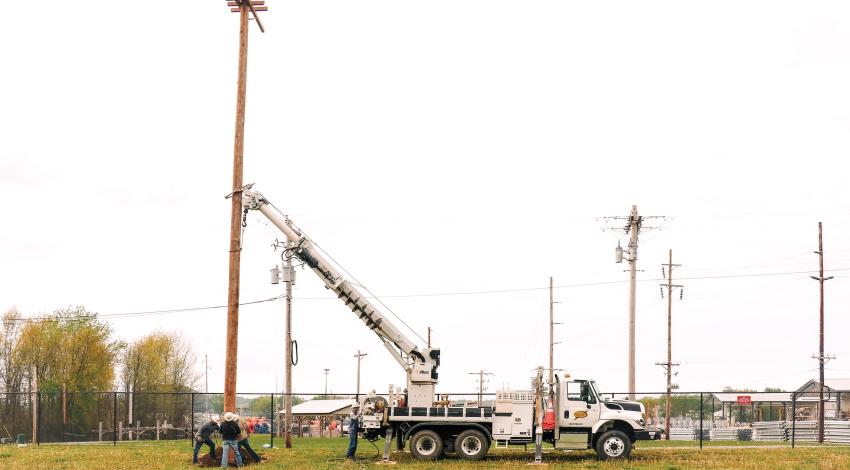 A group of lineworkers raising a nesting pole for a family of ospreys