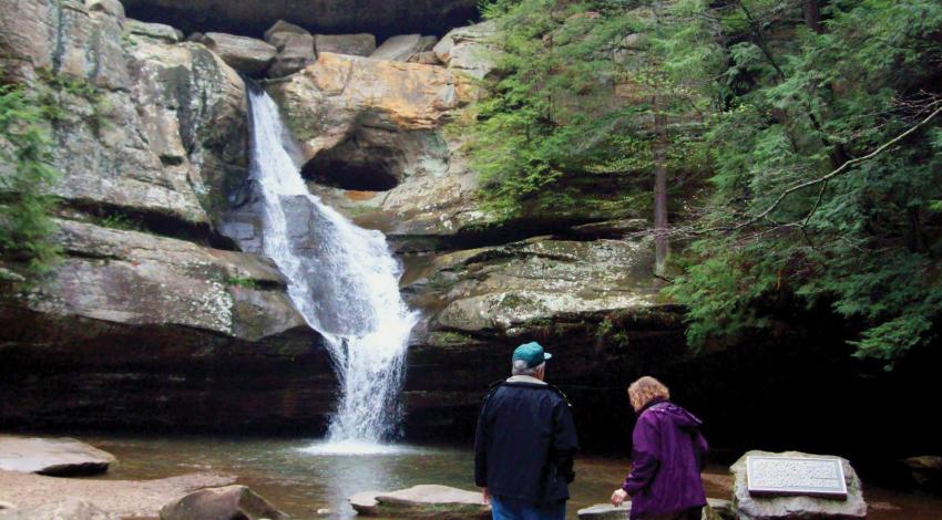 A couple looking at a waterfall in the woods