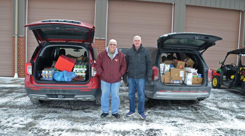 two people stand between cars filled with food