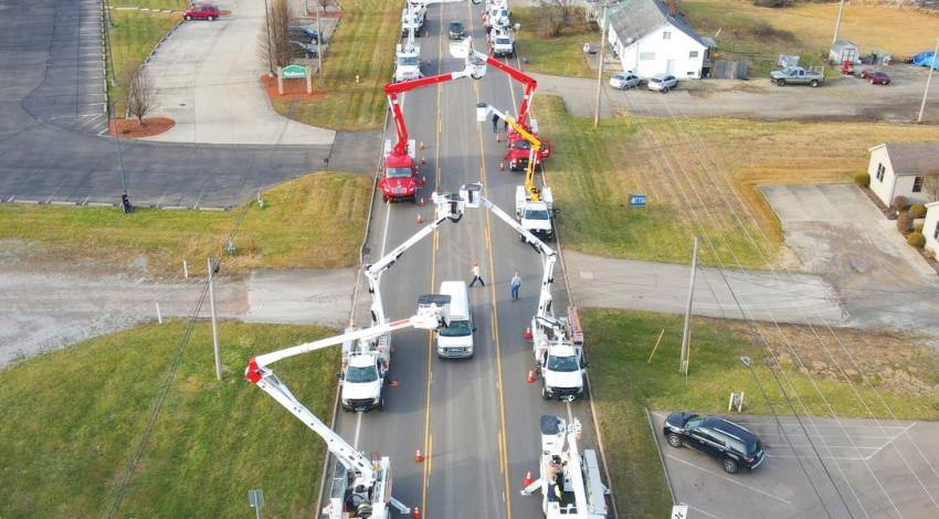 An arch made with bucket trucks over a funeral procession