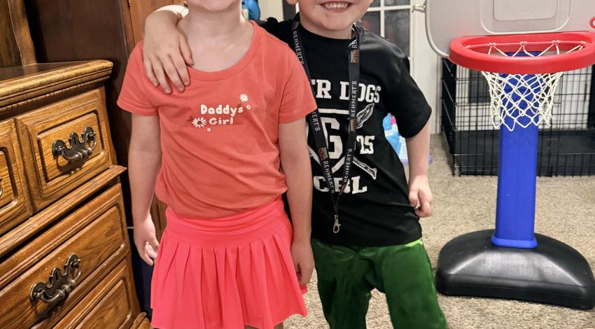 little boy with arm on little girl's shoulder