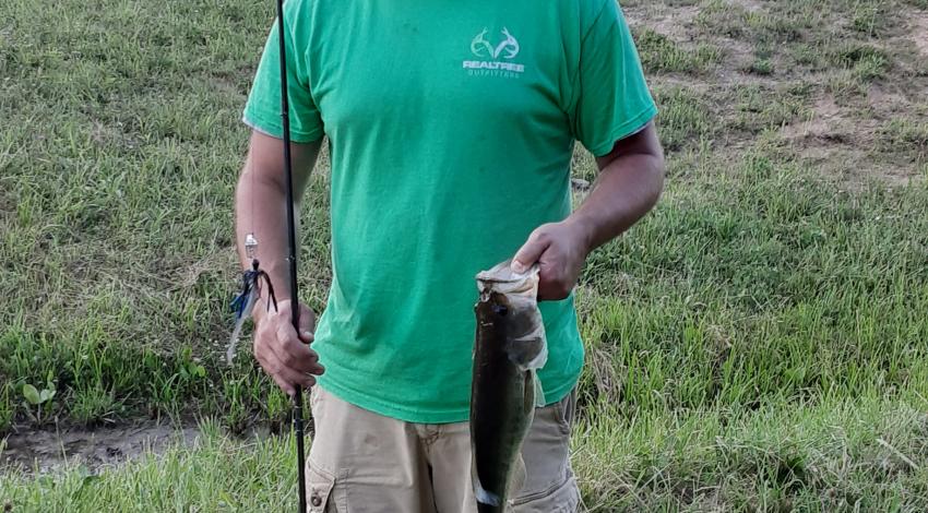 man smiling holding a fish