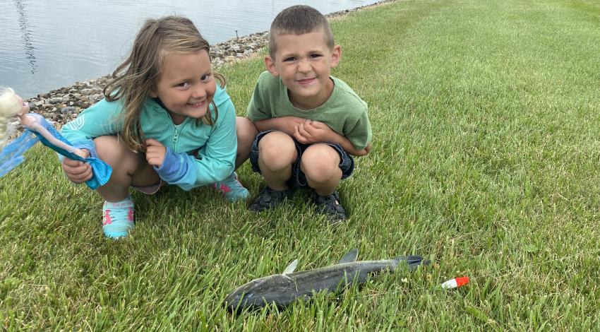 two children smiling with their fish