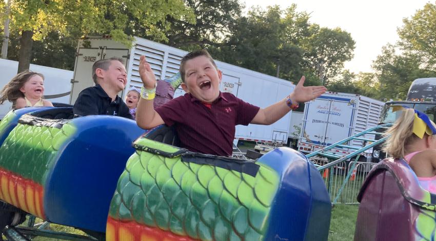 boy laughing on small roller coaster