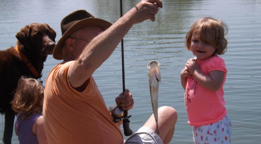 man teaching kids to fish
