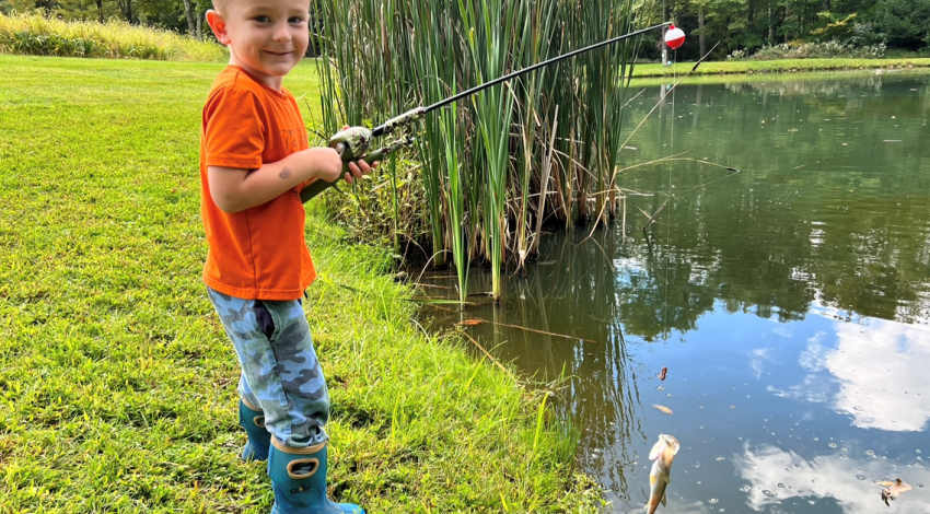 boy smiling holding a fish