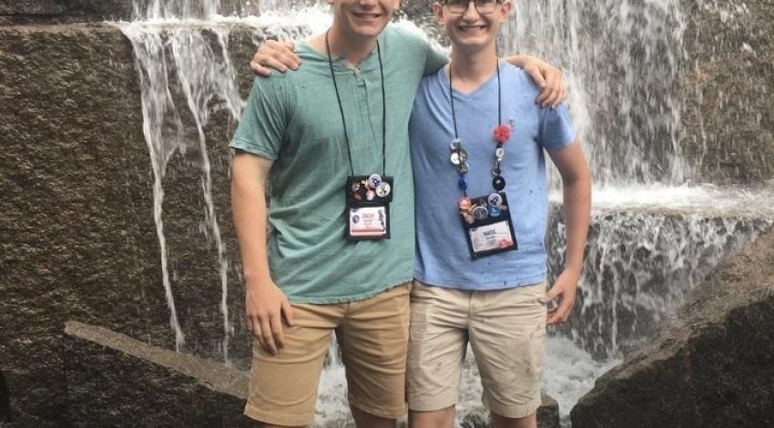Two teen boys in front of a waterfall