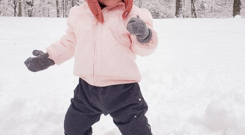 smiling little girl standing in the snow