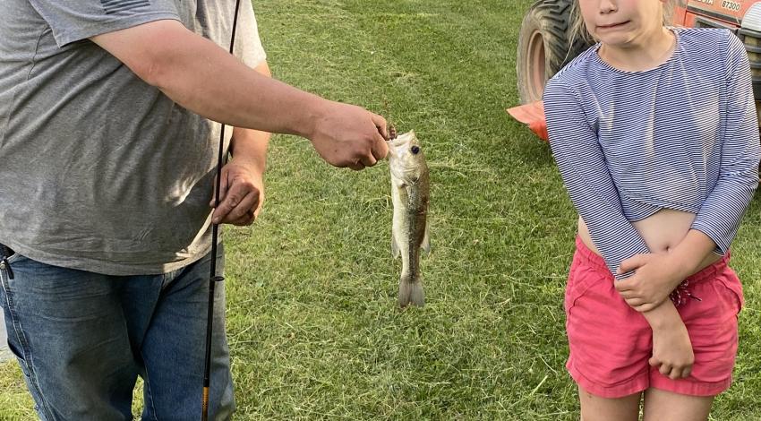 girl standing next to her first fish