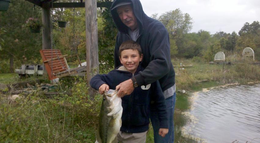 boy smiling while holding a fish