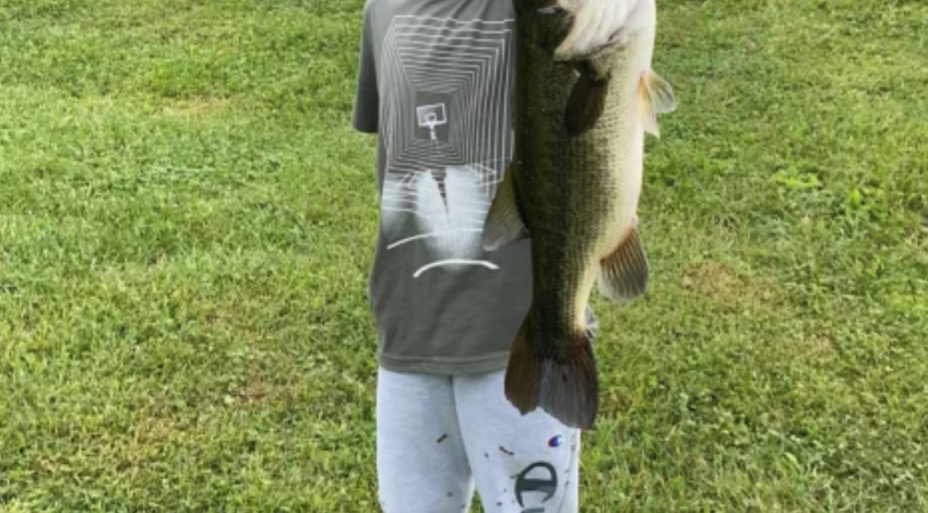Boy smiling holding a fish