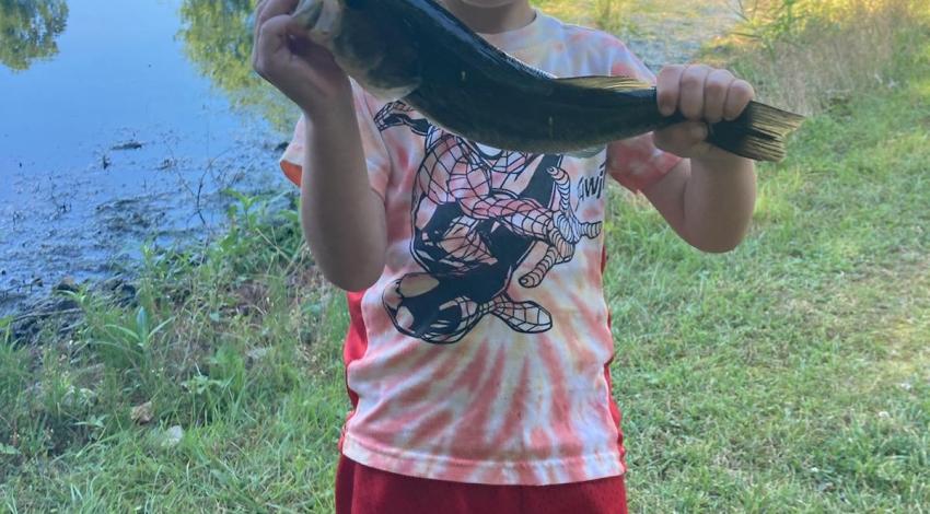 boy smiling holding a fish