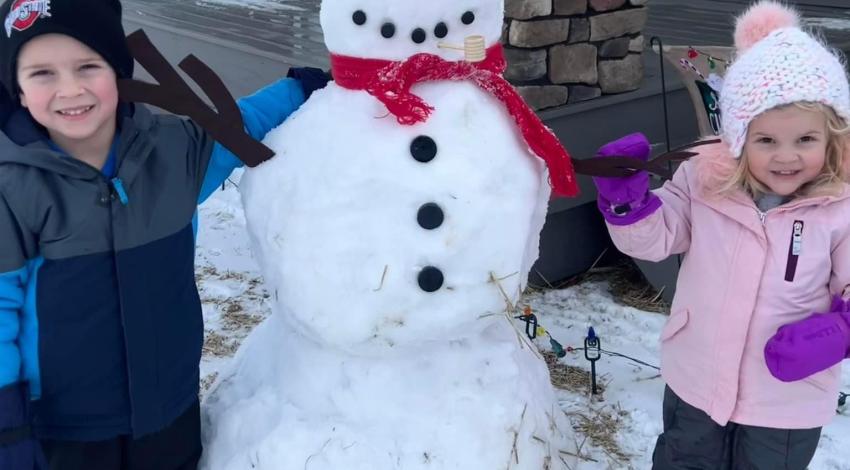 two children next to a snowman