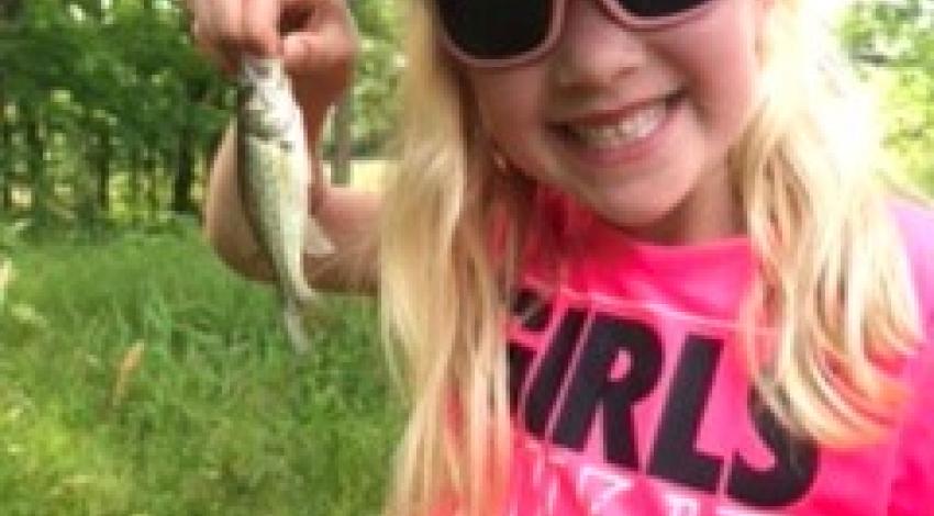 girl smiling holding a fish