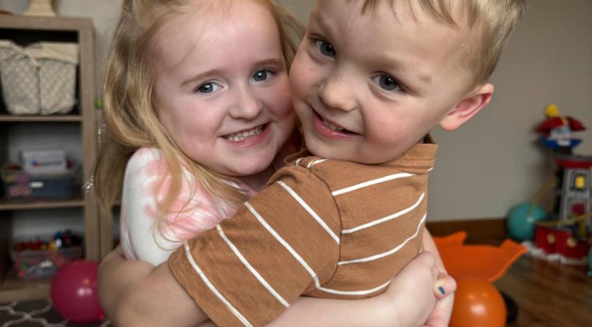 little girl and little boy hugging