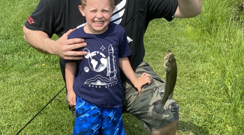 boy and his dad holding a fish