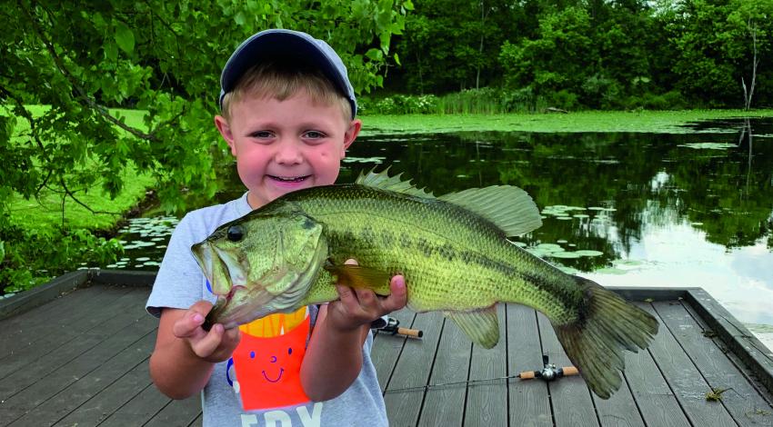 boy smiling holding a fish