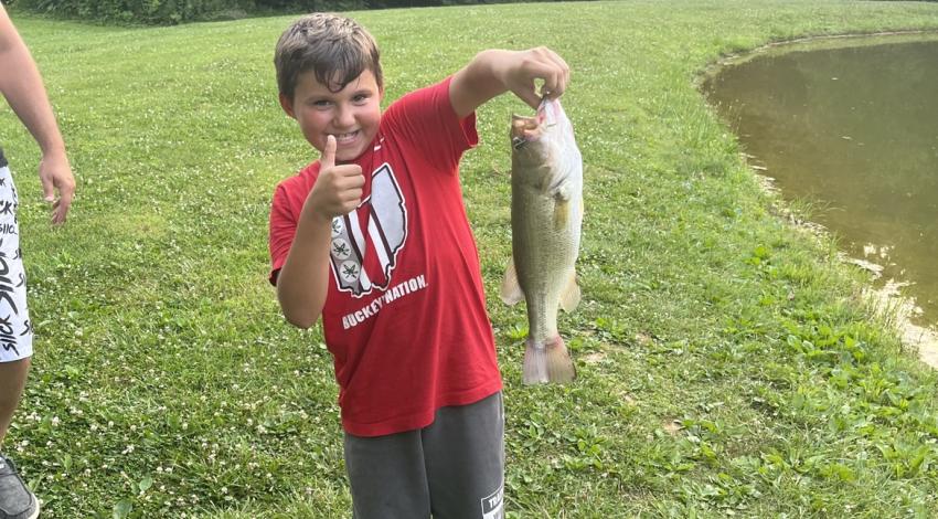 boy smiling holding a fish