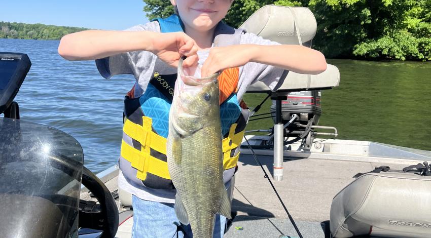 boy smiling holding a fish