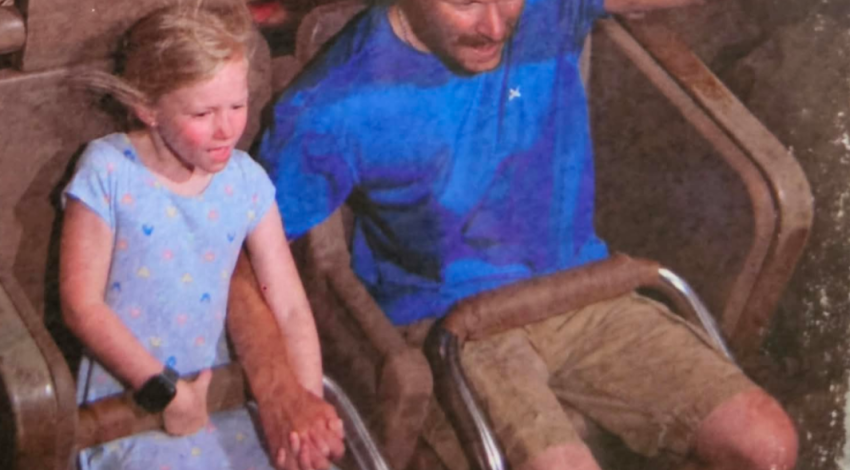 man and girl holding hands on roller coaster