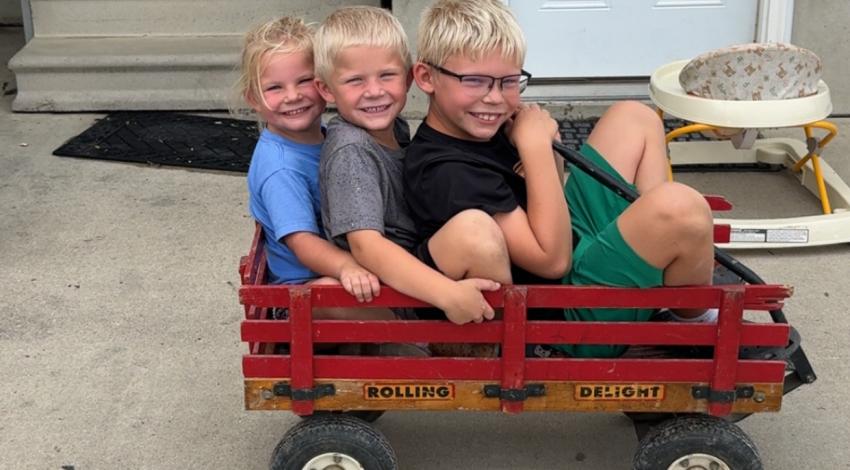 three kids in red wagon