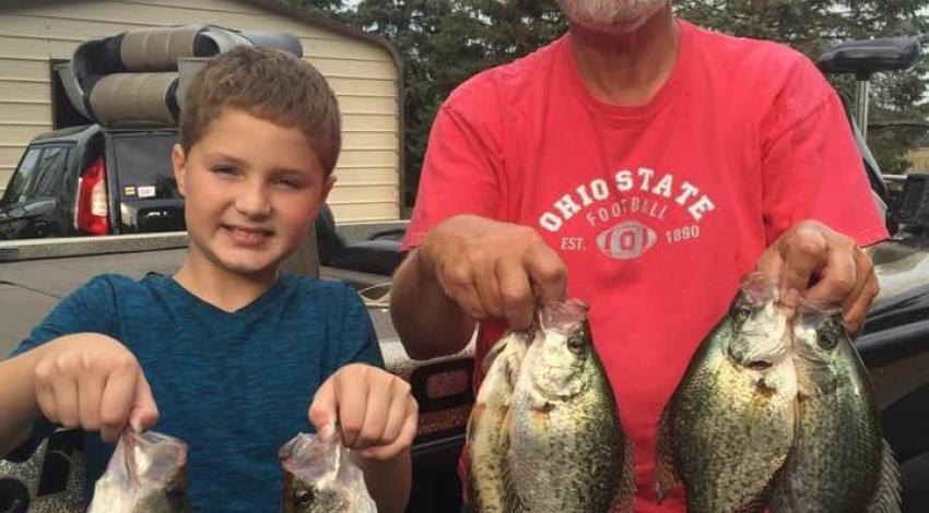 man and boy holding fish