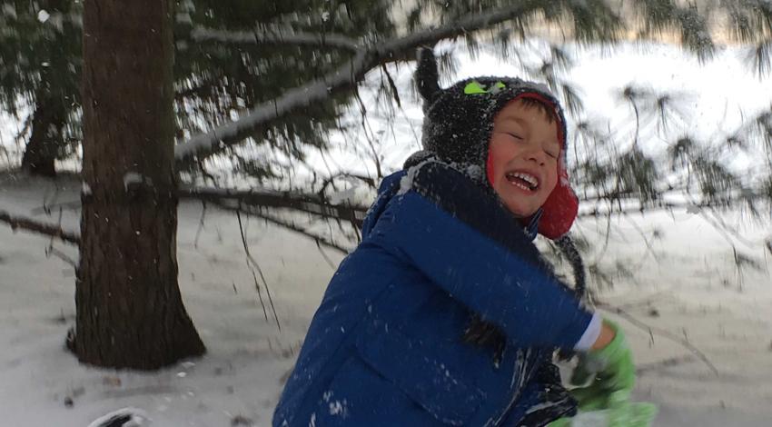smiling boy running in the snow