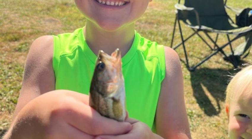 boy smiling holding a fish