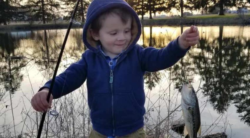 boy smiling holding a fish