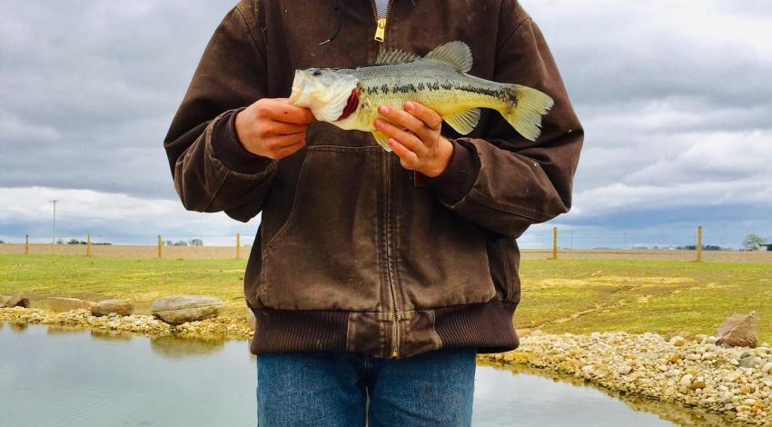 boy smiling while holding a fish