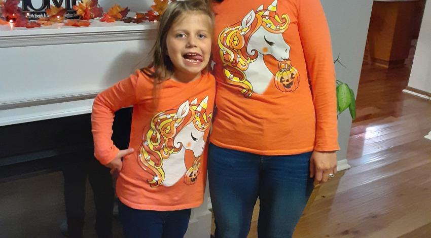 woman and girl in orange shirts, making funny faces